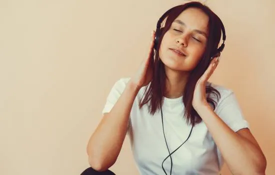 Joven escuchando música con auriculares sin pagar – música sin pagar