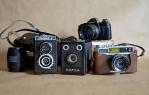 Cámaras fotográficas antiguas sobre una mesa, representando recuerdos y la posibilidad de recuperar tus fotos perdidas.